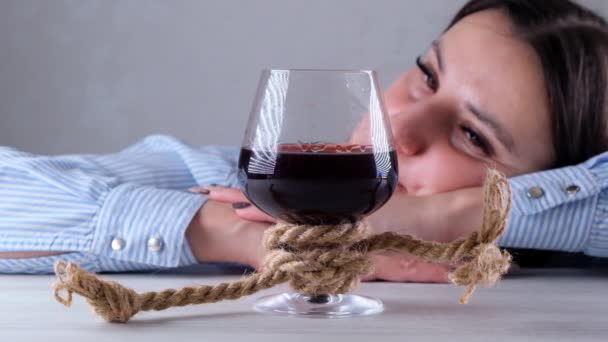 triste fêmea olhando copo de vinho amarrado com corda de juta. O conceito de dependência de álcool. O problema do tratamento do alcoolismo - Filmagem, Vídeo