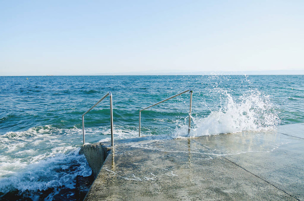 Beautiful sea background from a huge wave crashing against the coast on the Adriatic Sea in the town of Piran, Slovenia. Summer travel concept.  - Photo, Image