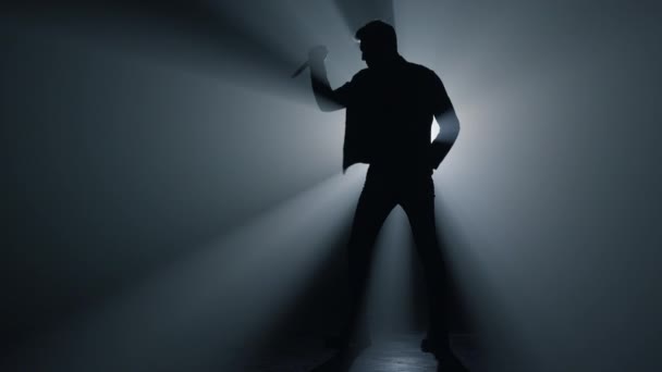 Uomo silhouette che tiene il coltello in mano nell'oscurità. Criminale in piedi con pugnale. - Filmati, video