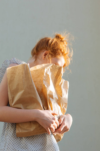 Fille rousse avec des achats dans des sacs en papier. - Photo, image