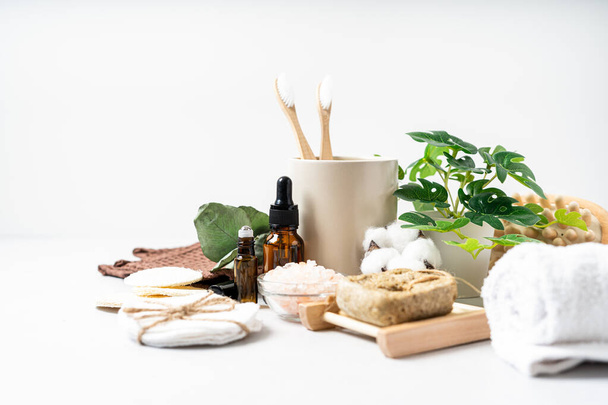 Natural bathroom and home spa tools. Zero waste sustainable lifestyle concept. Bamboo toothbrush, natural soap bar, cotton pads, homemade DIY beauty products in reusable bottles on white background - Φωτογραφία, εικόνα