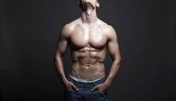 Hombre sexy en pantalones vaqueros. El culturista Boy. Hombre musculoso cuerpo desnudo. Gimnasio - Foto, imagen