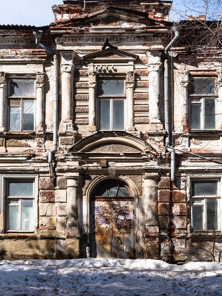 Saratov, Russia, March 30, 2019 - Facade of an old dilapidated mansion with an arched door and false columns. - Foto, Imagem