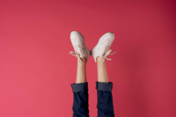 omgekeerde vrouwelijke benen sneakers mode bijgesneden uitzicht - Foto, afbeelding