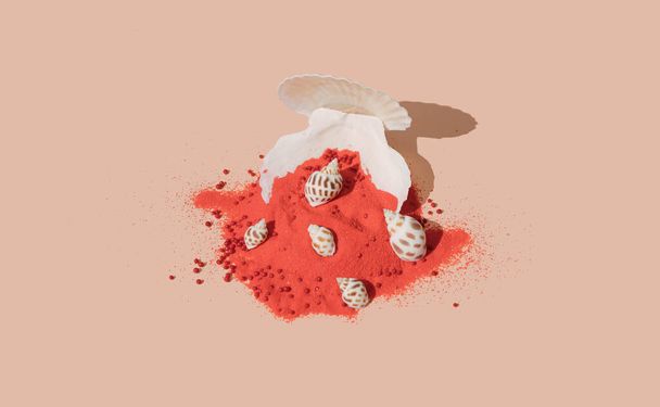 Creative seashell arrangement with red sand on pastel beige background. - Fotografie, Obrázek