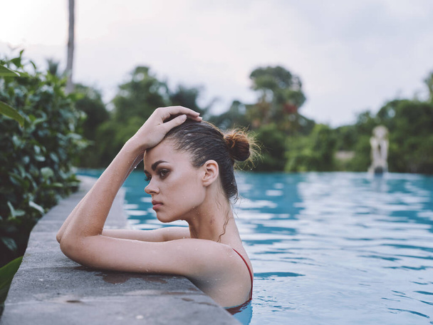 sexy Frau im Badeanzug lehnt an Pool-Fliese und Seitenansicht - Foto, Bild