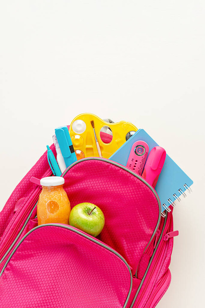 Full backpack with school stationery and lunch on white background. Top view, copy space - Valokuva, kuva