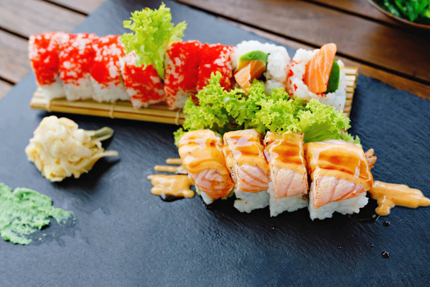 Sushi lançou camarão califórnia. Cozinha tradicional japonesa de fusão. Comida de entrega em qurantine. Arroz, nori, camarão tigre, pepino, abacate, molho de especiarias, caviar masago. - Foto, Imagem