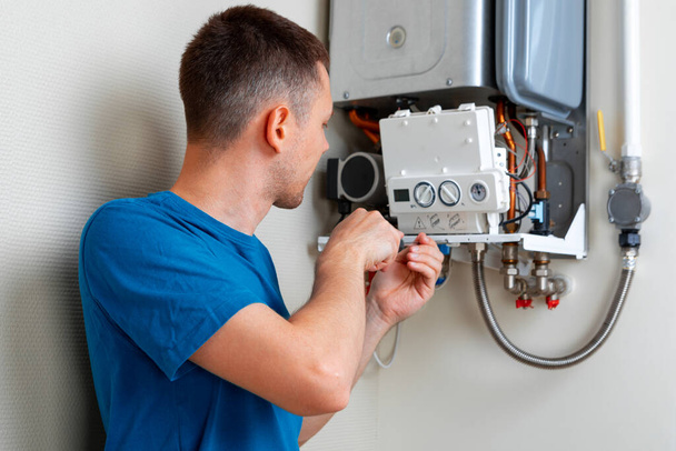 Plumber attaches Trying To Fix the Problem with the Residential Heating Equipment. Repair of a gas boiler - Photo, Image