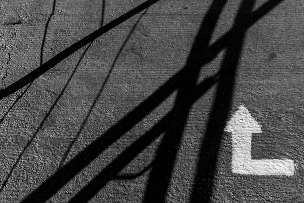 Vistas al suelo con flecha blanca indicativa y sombras. - Foto, Imagen