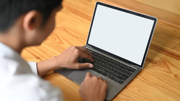 Imagen recortada de las manos está utilizando un ordenador portátil en el escritorio de madera. - Foto, Imagen