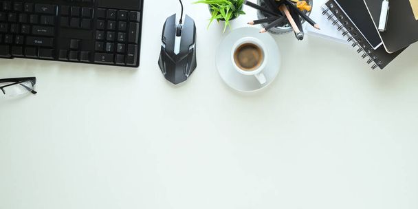 vista dall'alto della scrivania bianca con tastiera per pc, mouse, caffè e altre attrezzature per ufficio - Foto, immagini
