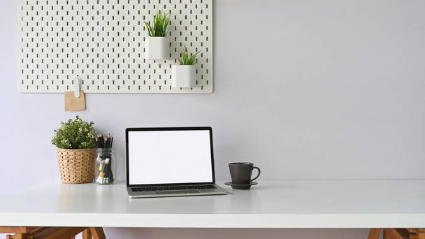 laptop με λευκή κενή οθόνη στο άνετο χώρο εργασίας - Φωτογραφία, εικόνα