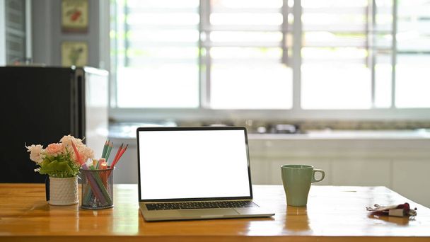 fehér üres képernyő laptop fa munkaasztal a konyhában - Fotó, kép