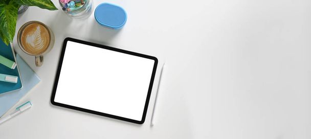 vista dall'alto del tablet digitale con schermo bianco sulla scrivania con caffè e forniture - Foto, immagini