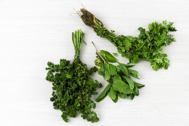 bundles of cilantro, mint and parsley isolated on white textured background. - Foto, Imagen