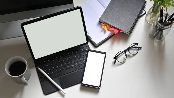beyaz boş ekran bilgisayar tableti ve çalışan masadaki akıllı telefon  - Fotoğraf, Görsel