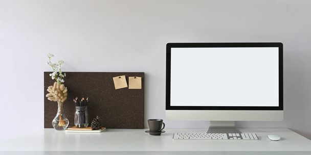 escritorio de trabajo blanco con pantalla blanca en blanco monitor de ordenador y decoraciones - Foto, Imagen