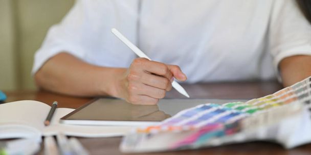 обрізана постріл жінка тримає кольорову палітру і використовує планшет зі стилусовою ручкою
 - Фото, зображення