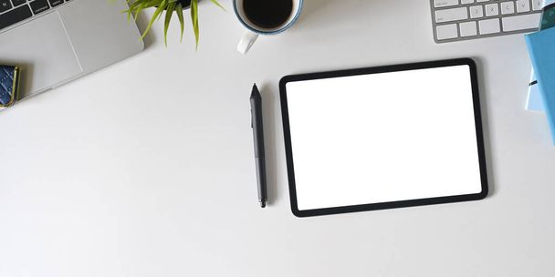 tableta s bílou obrazovkou, pero a kancelářské potřeby na stole - Fotografie, Obrázek