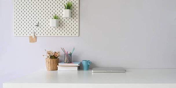 comfortable workspace with office equipment, laptop, cup and decorations - Foto, Bild