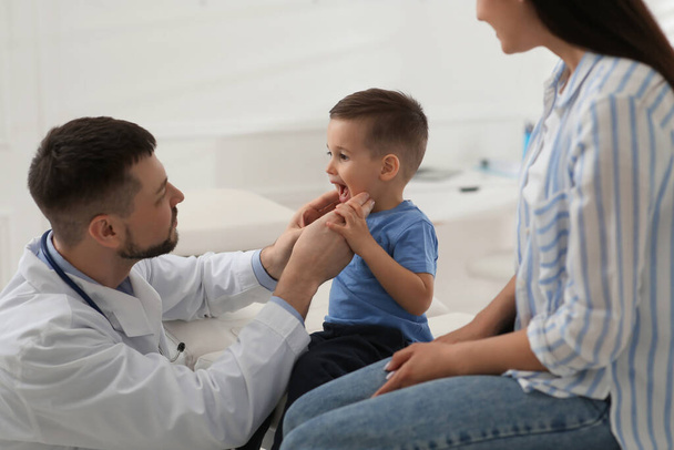 Mother and son visiting pediatrician in hospital. Doctor examining little boy - Foto, Imagem