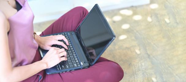 imagen recortada de la mujer usando el ordenador portátil en su regazo - Foto, Imagen