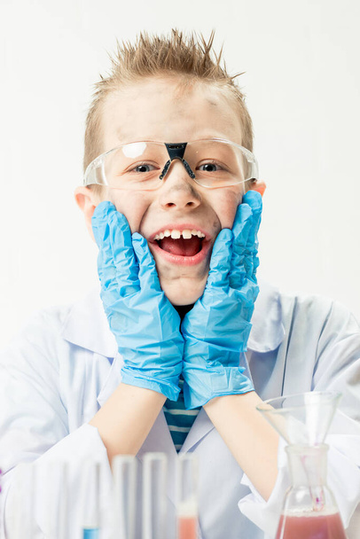 Zabawny chłopiec przebrany za chemika z brudną twarzą po nieudanym eksperymencie. - Zdjęcie, obraz