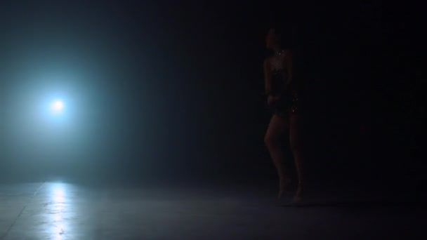 Kecses nő, aki reflektorfénybe ugrik. Fiatal tornász táncol otthon. - Felvétel, videó