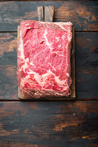 Żylasty stek, marmurkowa wołowina surowe mięso, na ciemnym drewnianym tle, widok z góry - Zdjęcie, obraz