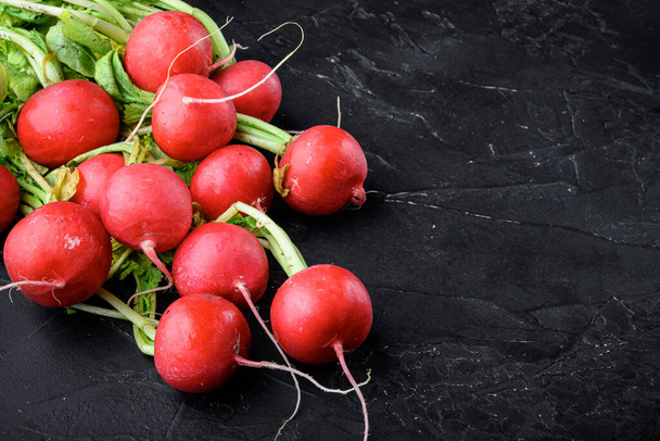 Un ramo de jugosos rábanos rojos Set de alimentos saludables, sobre fondo de piedra negra, con espacio para copiar texto - Foto, imagen