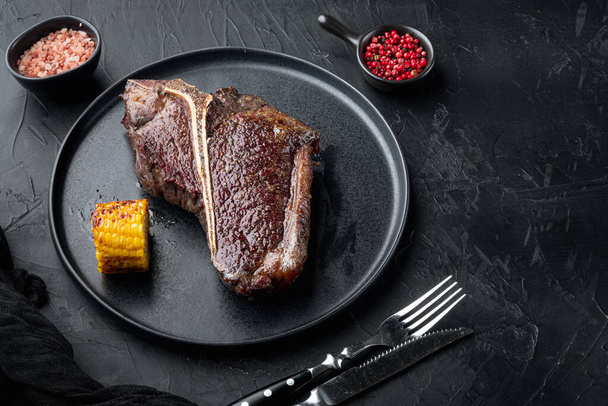 Carne de res envejecida T Bone steak. Filete cocido jugoso con romero y especias, en plato, con espacio de copia para texto - Foto, imagen