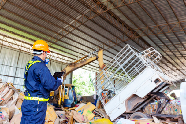 Engineer pointing forward. Engineer driving a loader in the recycling plant. - Photo, Image