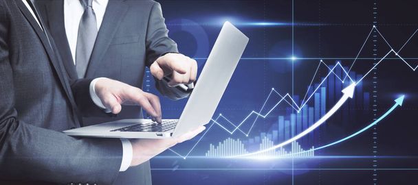 Businessmen using laptop with glowing forex chart interface. Teamwork and trade concept - Foto, Imagem