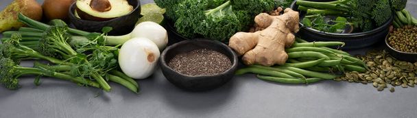 Assorted green vegetables and cereal on gray background. Healthy food concept. Panorama - Foto, imagen