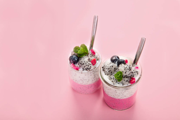 Layered chia puding with pink filling on pink background. Healthy breakfast concept - Foto, Bild