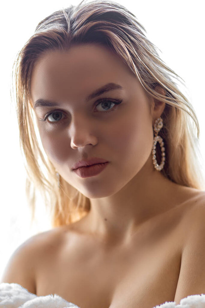Portrait of a young girl standing on an isolated white background, with bare shoulders - Фото, зображення