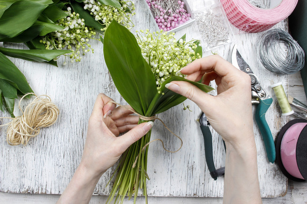 Florist at work. Woman making bouquet of lily of the valley flow - Photo, Image