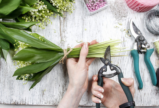 Florist at work. Woman making bouquet of lily of the valley flow - Φωτογραφία, εικόνα