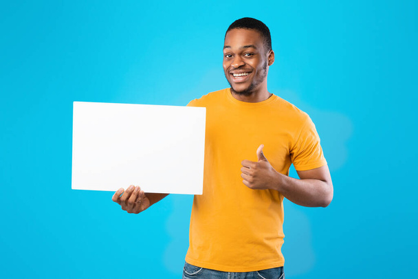 Black Guy Showing Blank White Board Gesturing Thumbs-Up, Blue Background - Foto, immagini