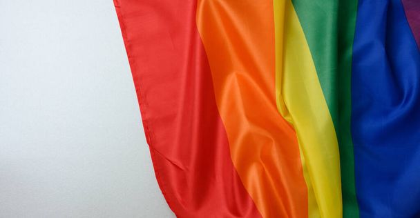 textile rainbow flag with waves, symbol of freedom of choice of lesbians, gays, bisexuals and transgender people, LGBT culture, copy space, banner - Photo, Image