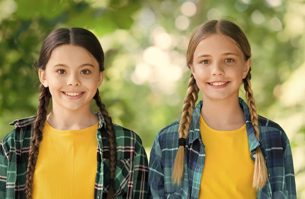 smiling kids. happy childrens day. spend time and have fun together. best school friends. concept of friendship. small happy girls wear checkered shirt. kid casual fashion. childhood happiness - Фото, зображення