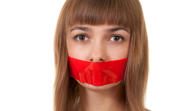 Beautiful girl with her mouth sealed with red tape - Photo, Image