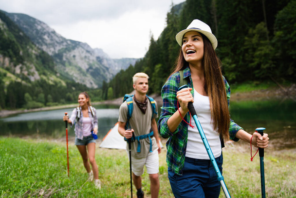 Adventure, travel, tourism, hike and people concept. Group of smiling friends with backpacks outdoors - 写真・画像