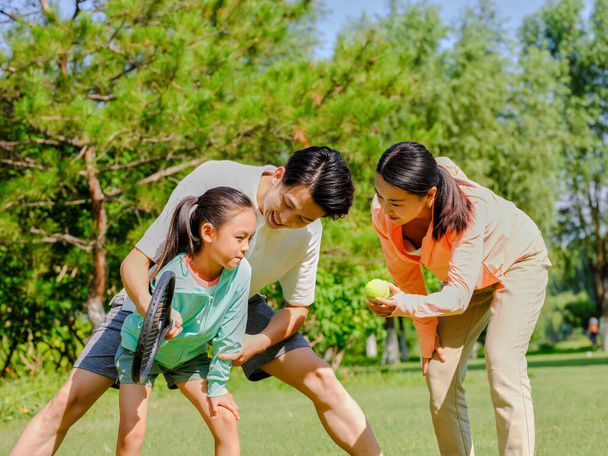 Happy family of three playing tennis in the park - Foto, Imagem