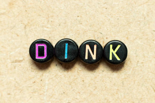 Fekete színű kerek ábécé betű blokk szóban DINK (Rövidítése kettős jövedelem, nincs gyerek vagy kettős jövedelem, nincs gyerek) a fa háttér - Fotó, kép