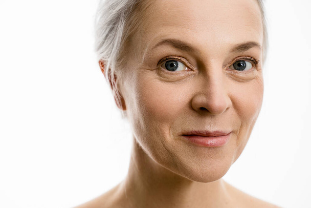Woman with perfect soft face skin looking to the camera and smiling while posing - Photo, image