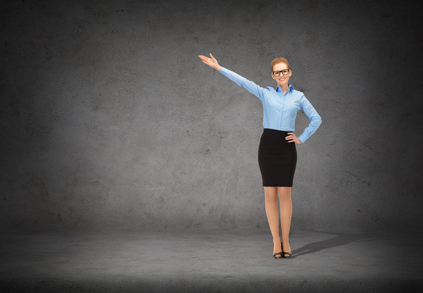 smiling businesswoman in glasses pointing her hand - Photo, image