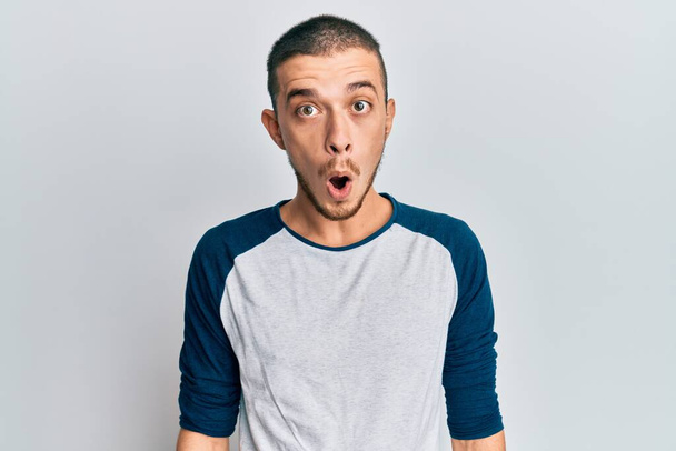 Hispanic young man wearing casual clothes afraid and shocked with surprise expression, fear and excited face.  - Photo, Image
