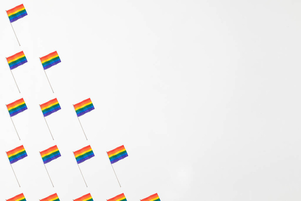Patrón de banderas de arco iris de la comunidad Lgtbi con sombra dura en el lado izquierdo, con espacio de copia sobre fondo blanco. Concepto del día del orgullo - Foto, Imagen